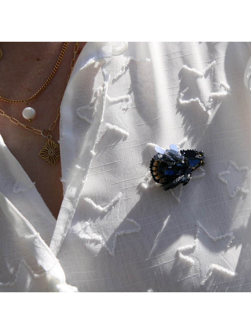 Navy blue bug brooch with wings.