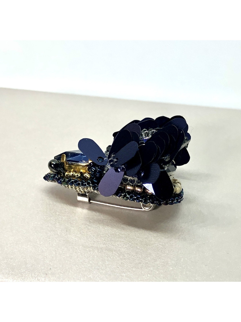 Navy blue bug brooch with wings.