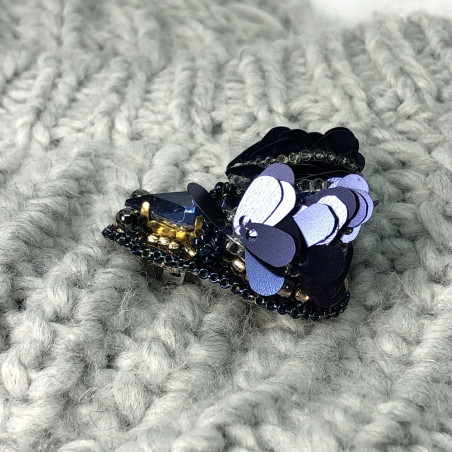 Navy blue bug brooch with wings.